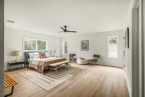 a bed room with a bed couches and a window