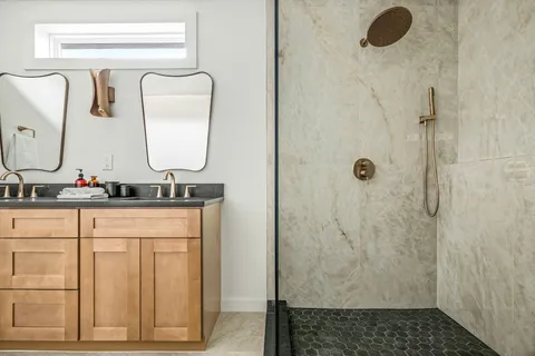 a bathroom with a granite countertop sink and a mirror