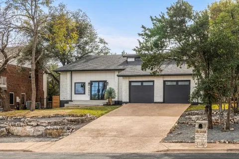 a front view of a house with yard and trees