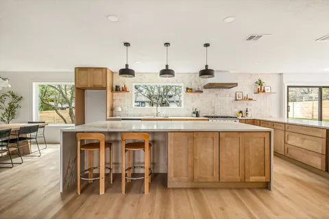 a kitchen with stainless steel appliances granite countertop a stove and cabinets with wooden floor