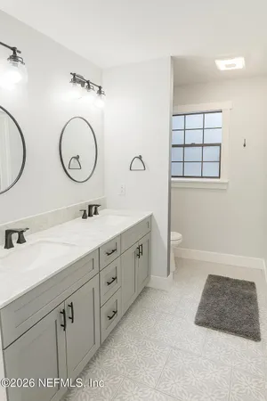a spacious bathroom with a double vanity sink and a mirror