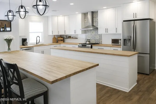 a kitchen with stainless steel appliances granite countertop a sink a refrigerator and a stove