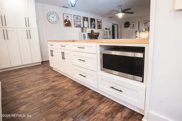 a kitchen with stainless steel appliances white cabinets and a wooden floor