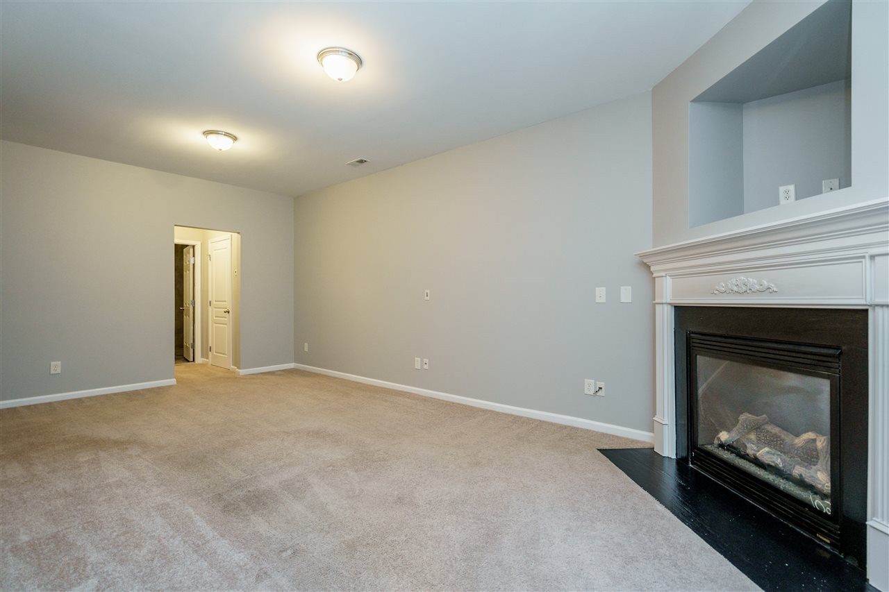 7675 Winners Edge Street Raleigh, NC 27617 - Photo 16 of 23 an empty room with a fireplace and wooden floor