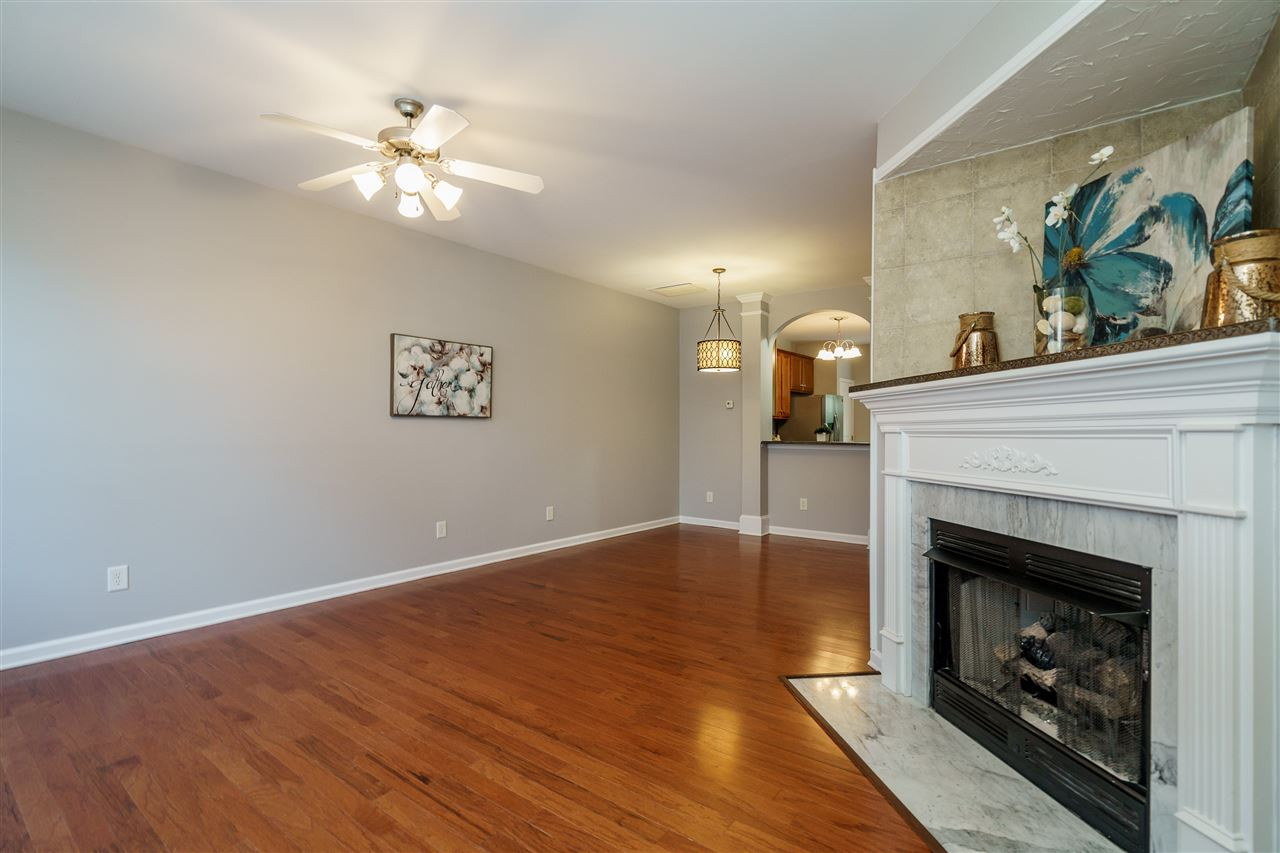 7675 Winners Edge Street Raleigh, NC 27617 - Photo 2 of 23 a view of a livingroom with a fireplace a chandelier and wooden floor