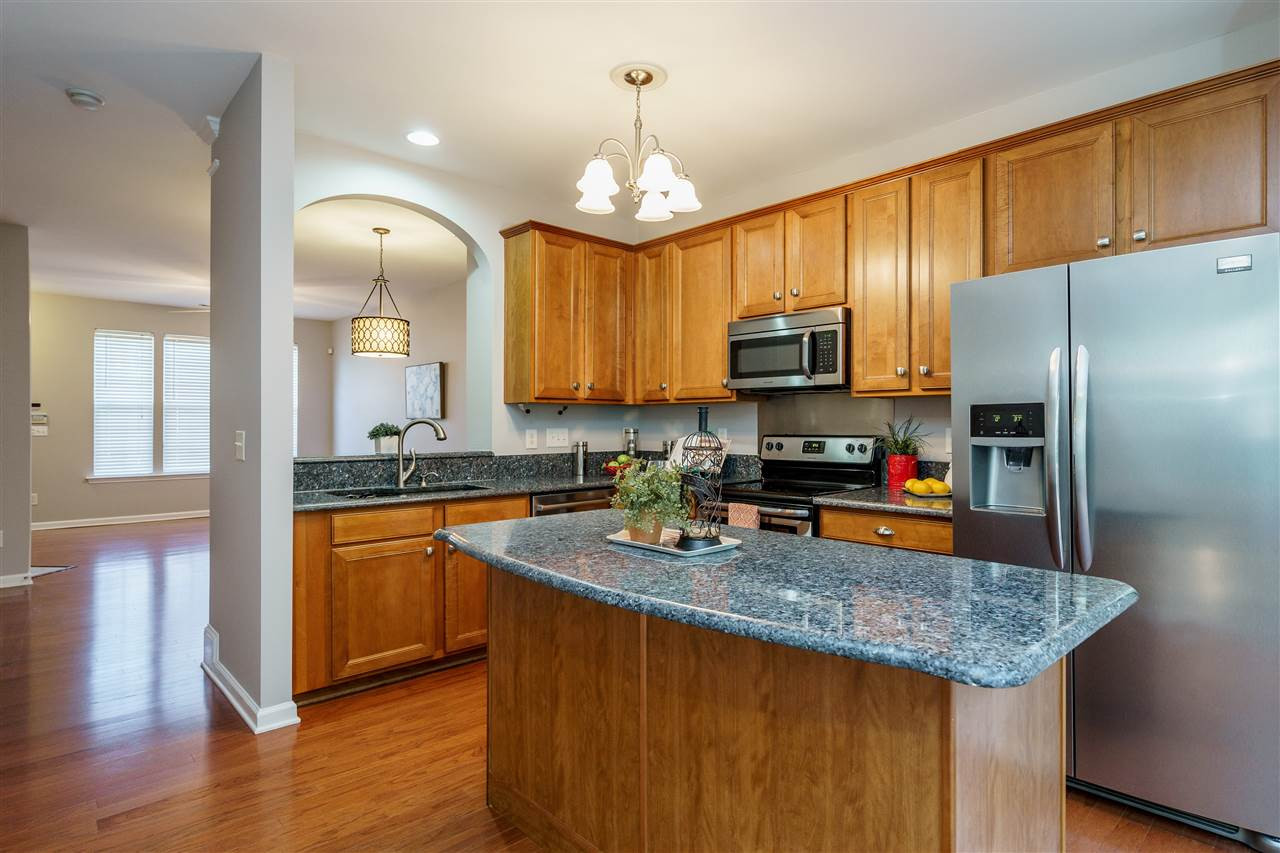 7675 Winners Edge Street Raleigh, NC 27617 - Photo 8 of 23 a kitchen with stainless steel appliances granite countertop a sink a stove a refrigerator cabinets and wooden floor