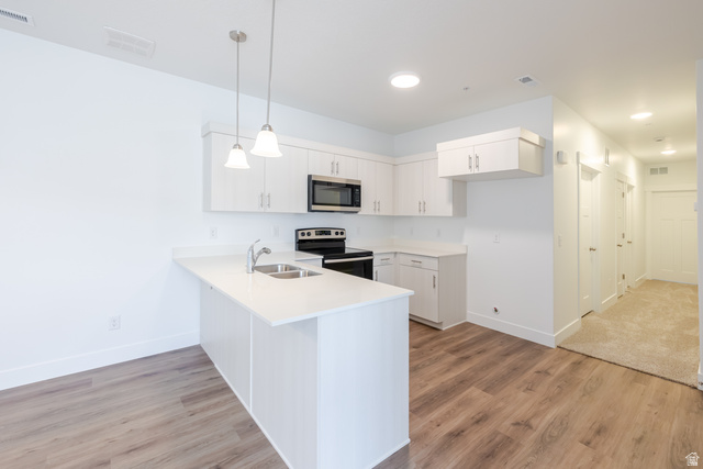 675 West 4500th South, Unit P302 Mapleton, UT 84664 - Photo 12 of 16 Kitchen featuring white cabinetry, stainless steel appliances, a double basin sink, and pendant lighting over a peninsula