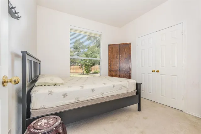a bed sitting in a spacious bedroom next to a window
