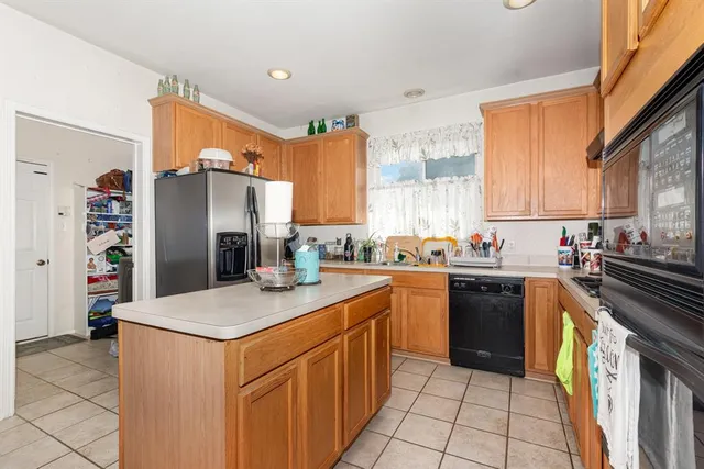 a kitchen with stainless steel appliances granite countertop a refrigerator sink and stove