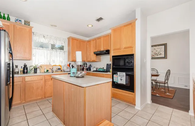 a kitchen with stainless steel appliances granite countertop a refrigerator and a stove top oven