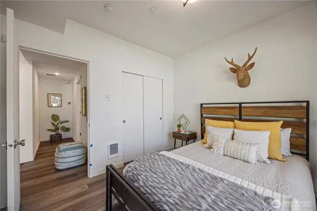 a bedroom with a bed and wooden floor