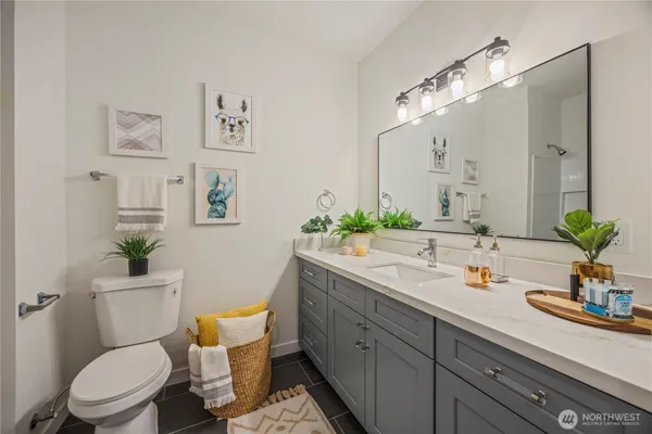 a bathroom with a granite countertop toilet sink and mirror