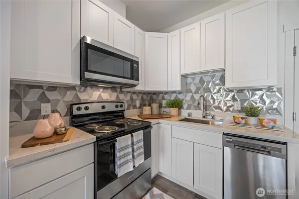 a kitchen with stainless steel appliances granite countertop a sink stove and microwave