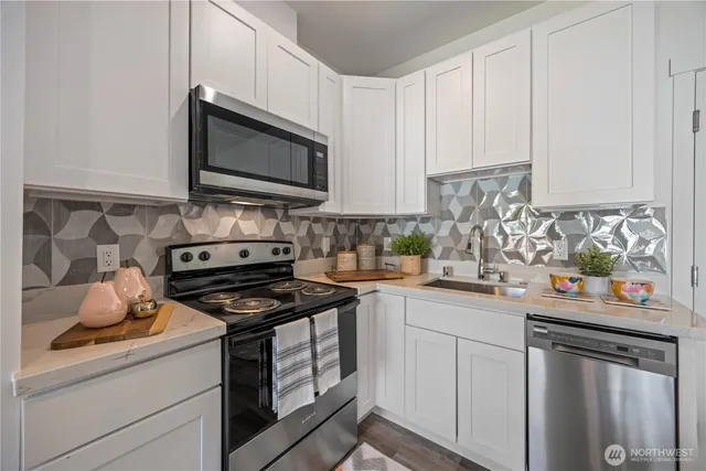 a kitchen with stainless steel appliances granite countertop a sink stove and microwave