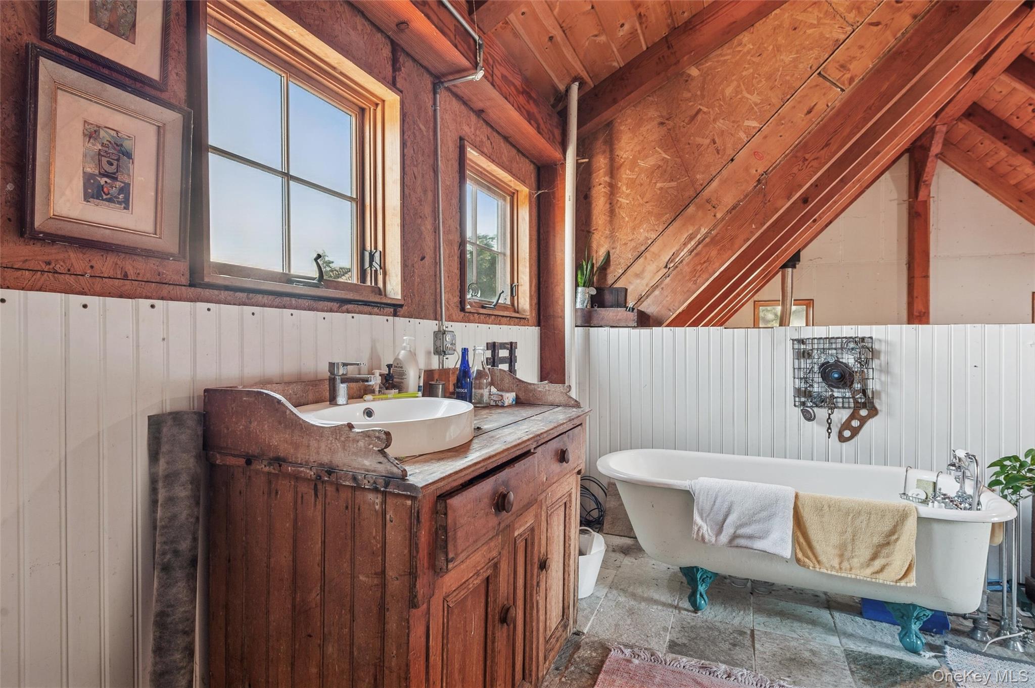 7 Jagger Lane Westhampton, NY 11977 - Photo 15 of 22 Bathroom featuring a freestanding bath, vanity, lofted ceiling, wood walls, and stone tile flooring