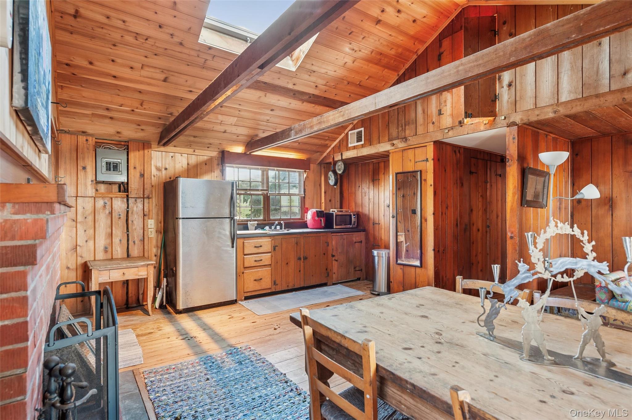 7 Jagger Lane Westhampton, NY 11977 - Photo 17 of 22 Kitchen featuring stainless steel appliances, light wood-style floors, wood ceiling, wood walls, and brown cabinetry