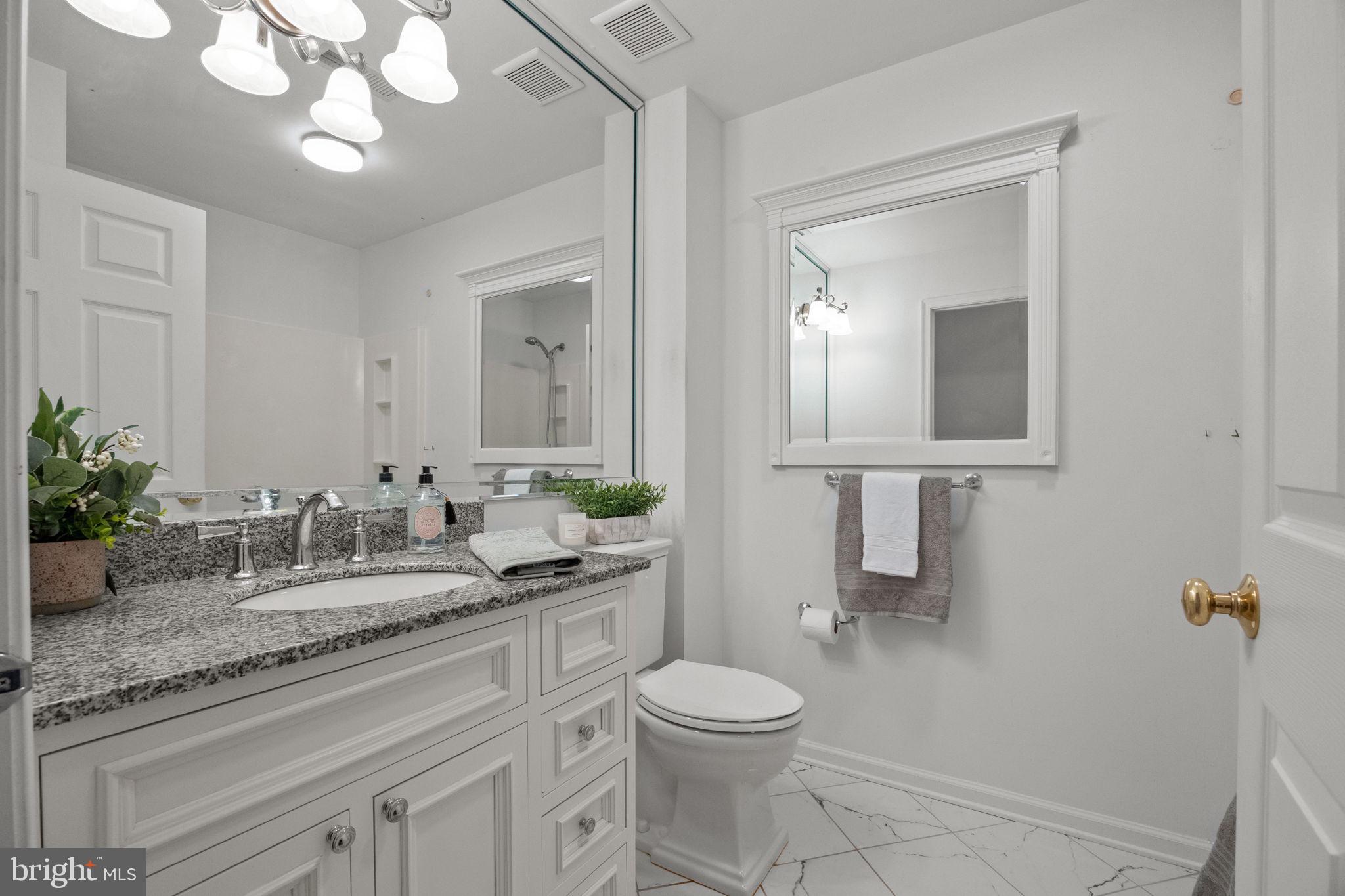 1102 Waterford Road, Unit 1 Yardley, PA 19067 - Photo 22 of 31 a bathroom with a granite countertop toilet sink and mirror