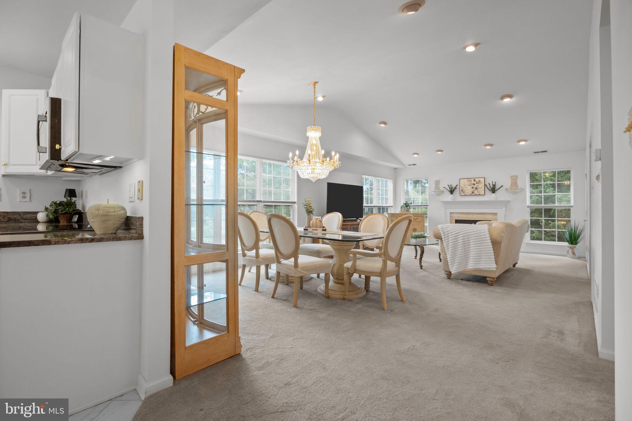 1102 Waterford Road, Unit 1 Yardley, PA 19067 - Photo 3 of 31 a view of a dining room with furniture a chandelier and a large window