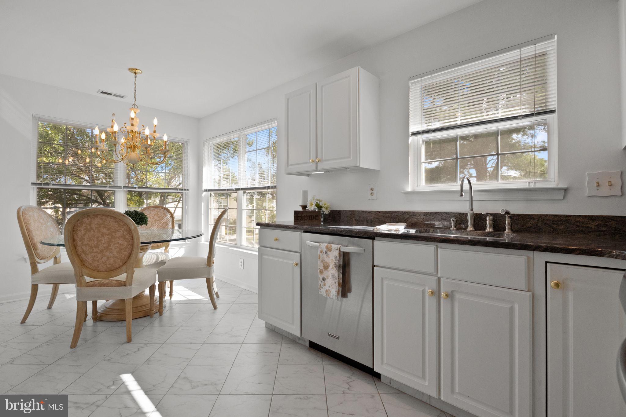 1102 Waterford Road, Unit 1 Yardley, PA 19067 - Photo 7 of 31 a kitchen with a dining table chairs and white cabinets