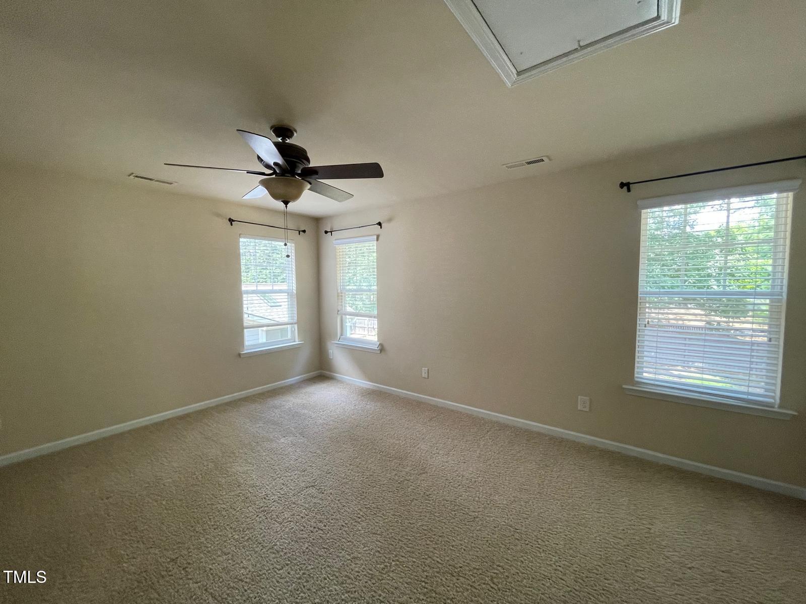 2107 Toad Hollow Trail Apex, NC 27502 - Photo 14 of 28 en empty room with windows and ceiling fan