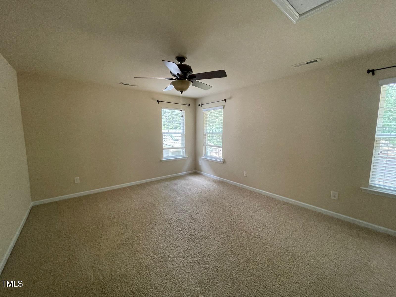 2107 Toad Hollow Trail Apex, NC 27502 - Photo 22 of 28 an empty room with windows and chandelier fan
