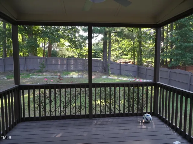 a view of a backyard with a tree and wooden fence