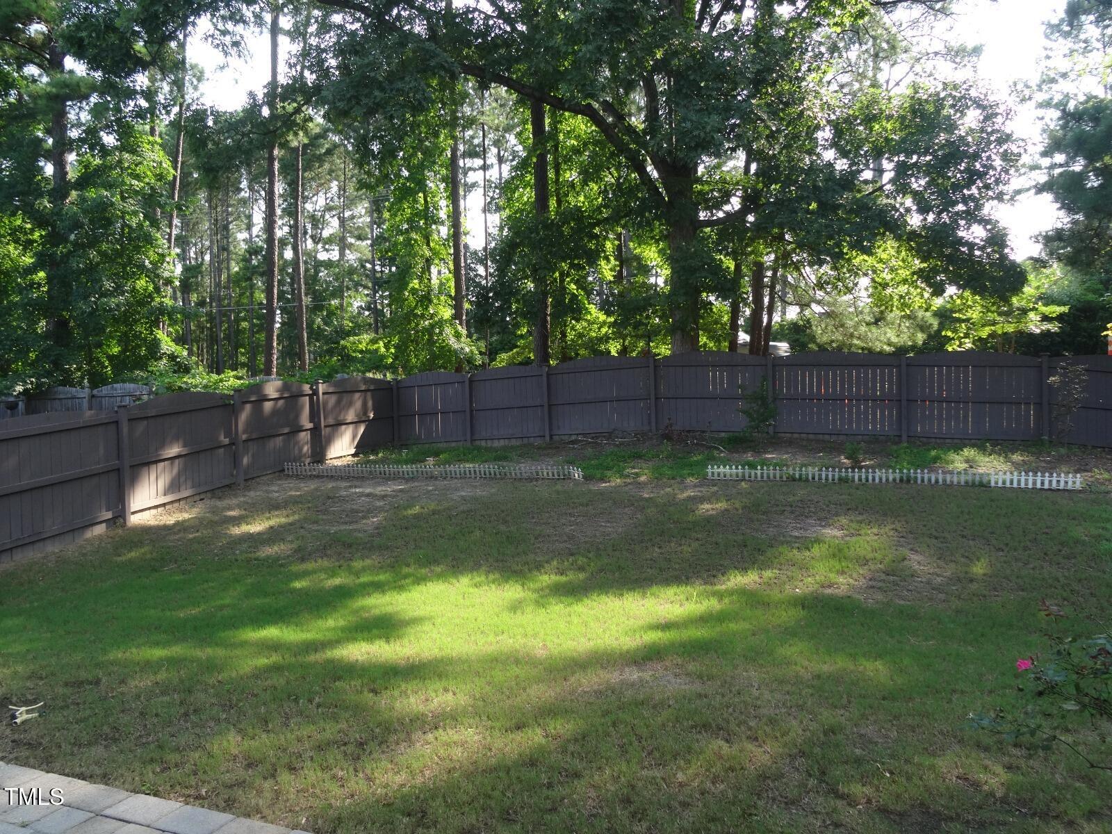 2107 Toad Hollow Trail Apex, NC 27502 - Photo 28 of 28 a view of a backyard with a tree and wooden fence