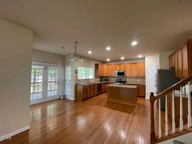 a view of kitchen with wooden floor and electronic appliances