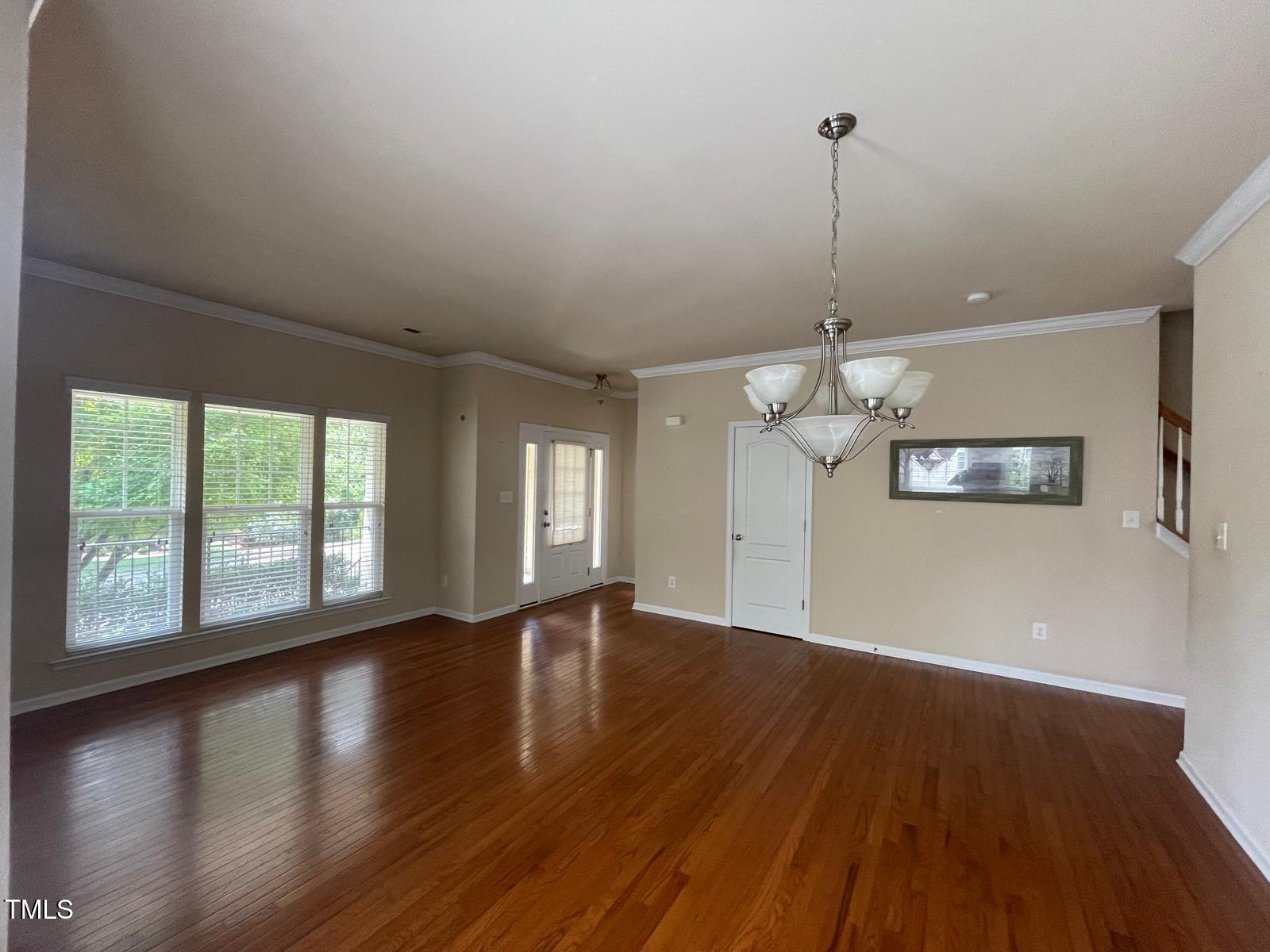 2107 Toad Hollow Trail Apex, NC 27502 - Photo 4 of 28 a view of an empty room with wooden floor and a window