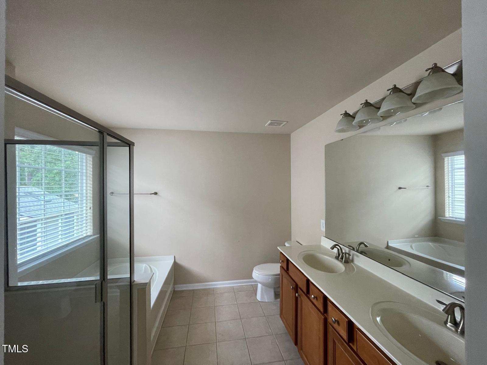 2107 Toad Hollow Trail Apex, NC 27502 - Photo 7 of 28 a bathroom with a double vanity sink a toilet and a mirror