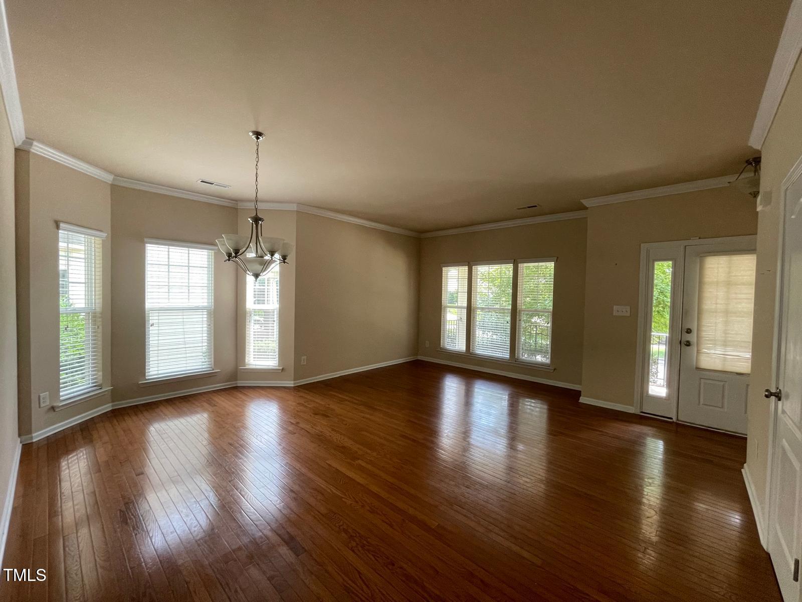 2107 Toad Hollow Trail Apex, NC 27502 - Photo 8 of 28 a view of an empty room with wooden floor and a window