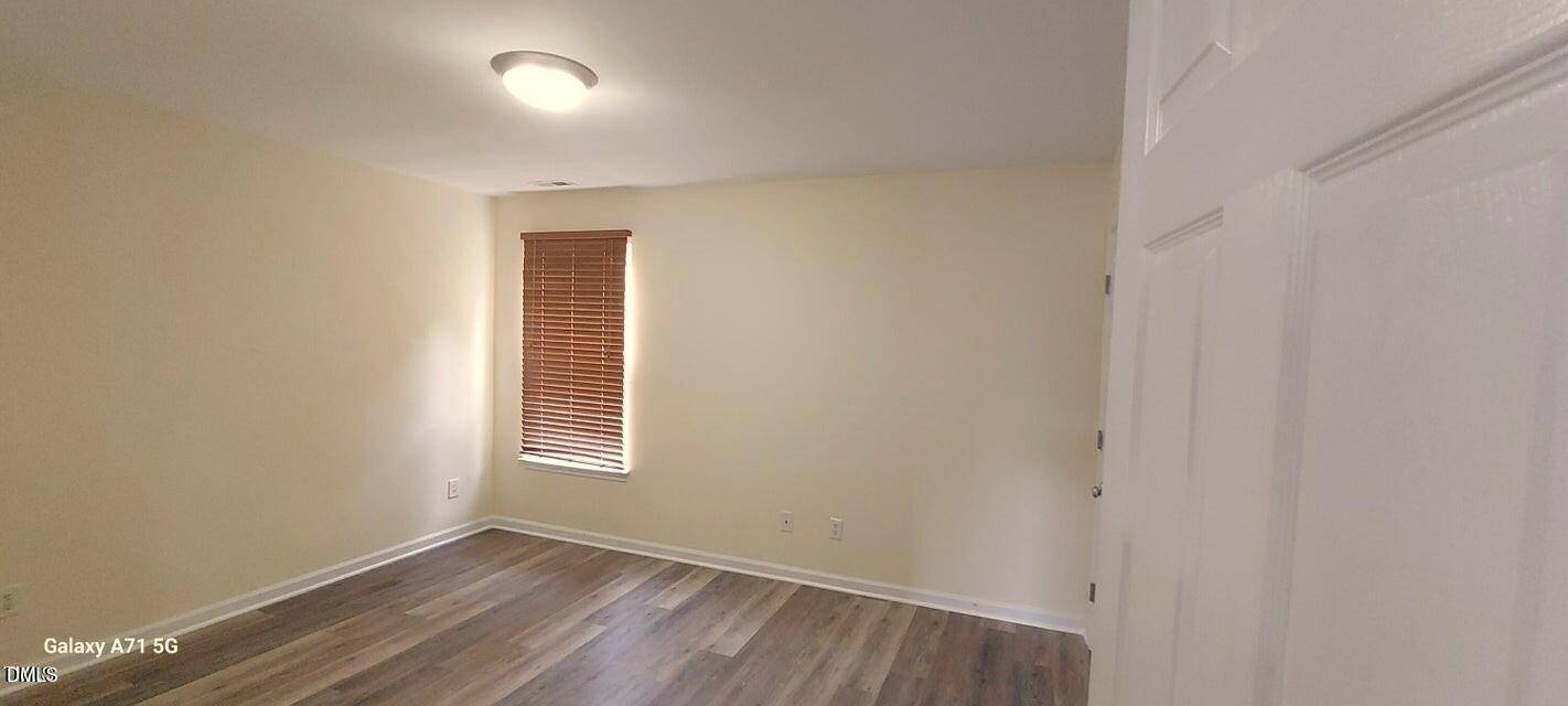 201 Jasper Point Drive Holly Springs, NC 27540 - Photo 13 of 23 a view of a room with wooden floor and windows
