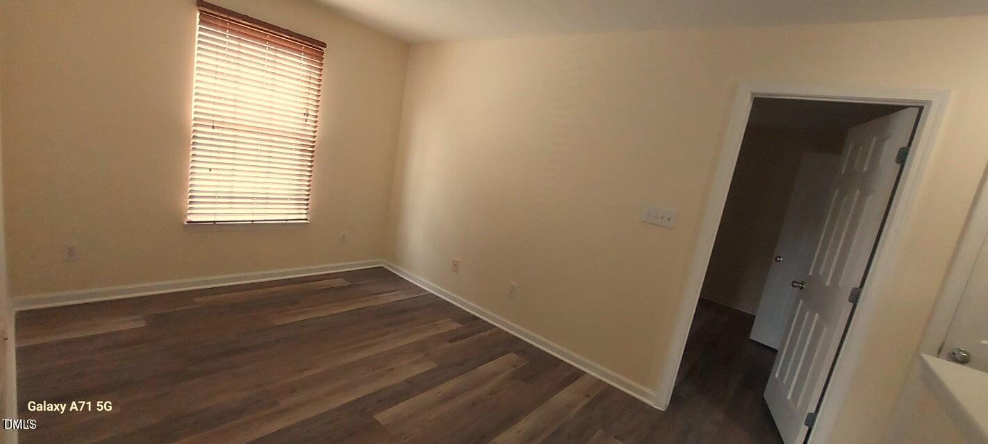 201 Jasper Point Drive Holly Springs, NC 27540 - Photo 22 of 23 an empty room with wooden floor and windows