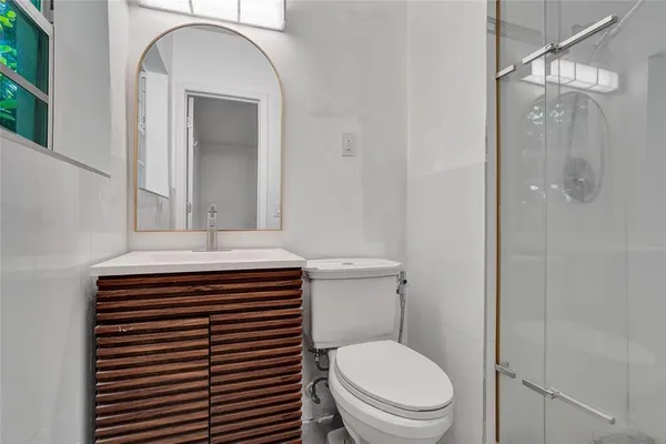 a bathroom with a sink a toilet and shower