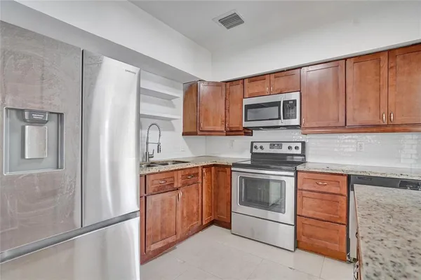 a kitchen with sink a microwave and refrigerator