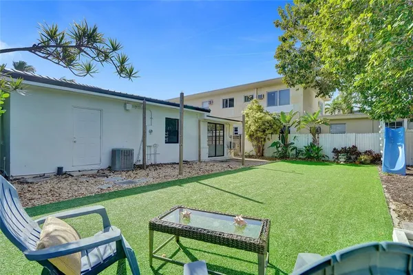 a backyard of a house with table and chairs