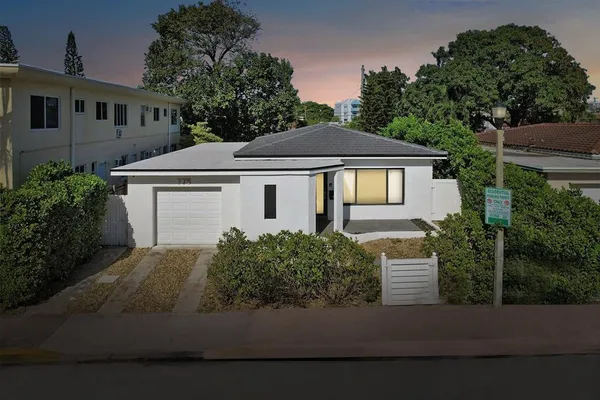 a front view of a house with a garden