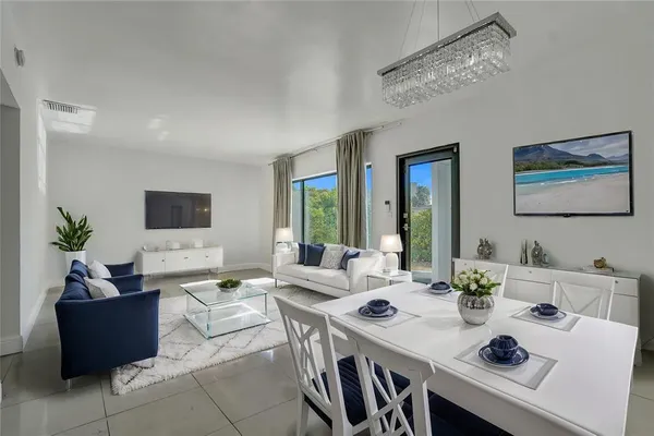 a living room with furniture a large window and a chandelier