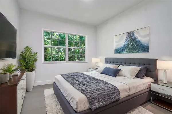a bedroom with a large bed and a potted plant
