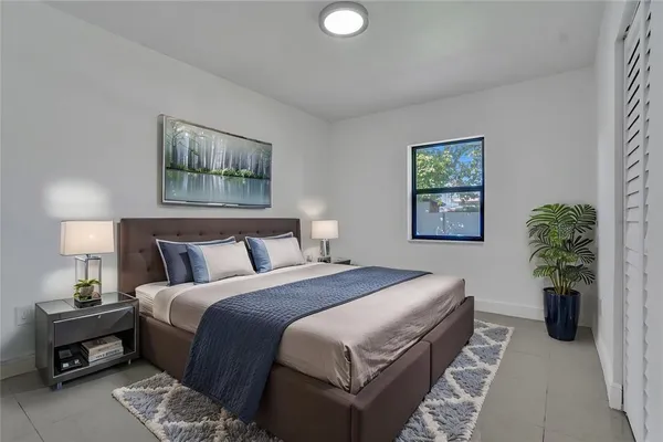 a bedroom with bed and a potted plant