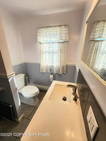 a bathroom with a sink a toilet and a window
