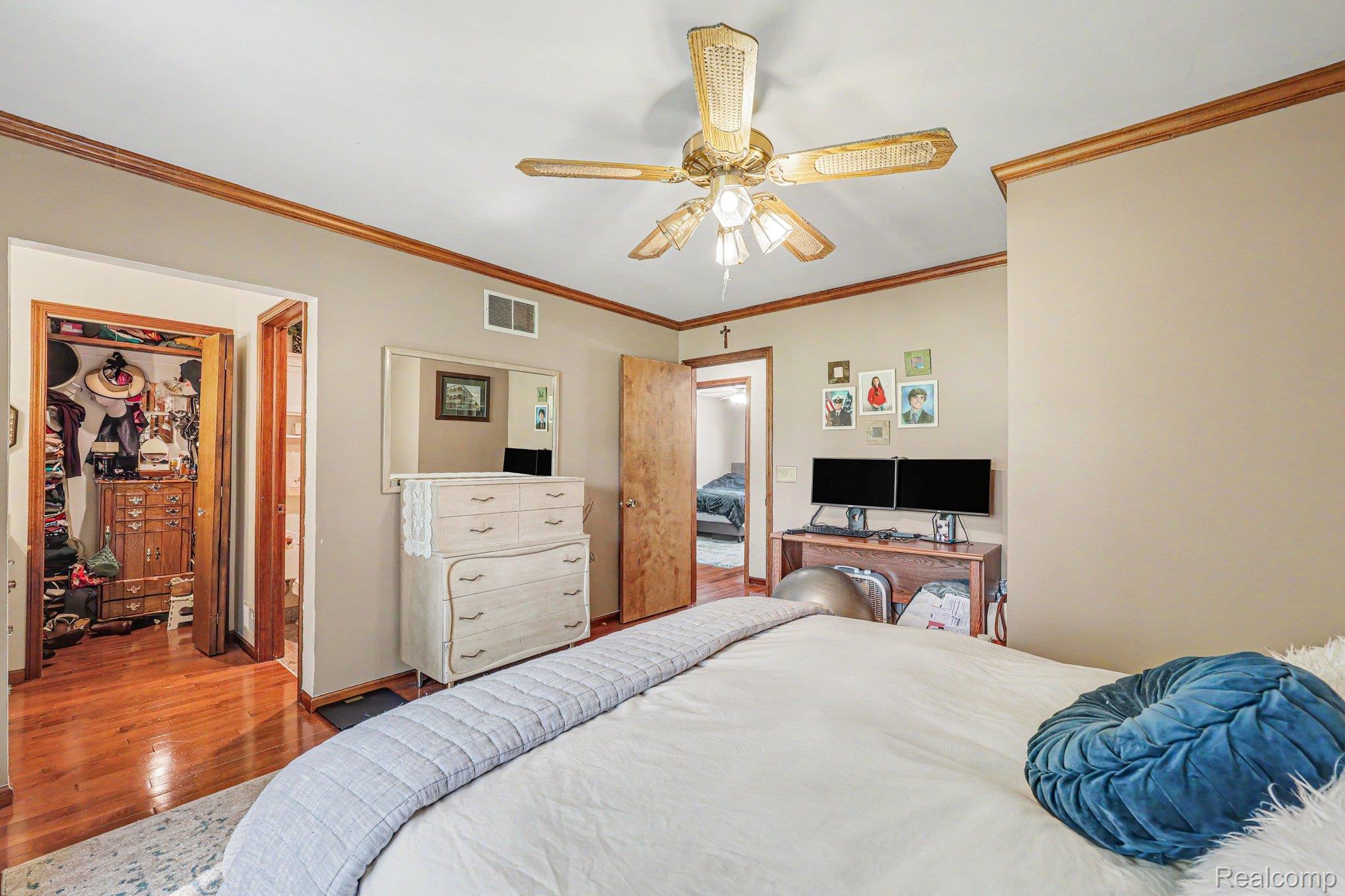 7020 Meldrum Road Fair Haven, MI 48023 - Photo 21 of 43 Bedroom featuring warm-toned walls, wood-finish crown molding, and a ceiling fan with integrated lighting