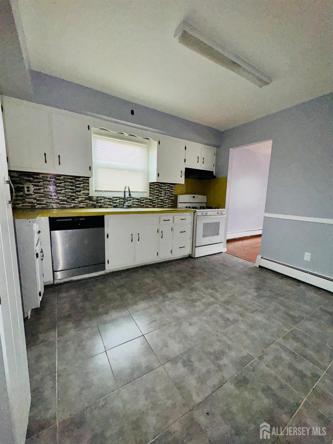 32 Union Place Irvington, NJ 07111 - Photo 12 of 14 a large kitchen with cabinets and stainless steel appliances