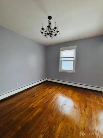 a view of a room with wooden floor and chandelier