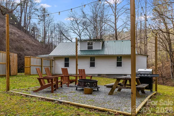 a backyard of a house with barbeque oven table and chairs
