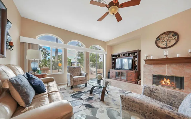 a living room with furniture a large window and a fireplace