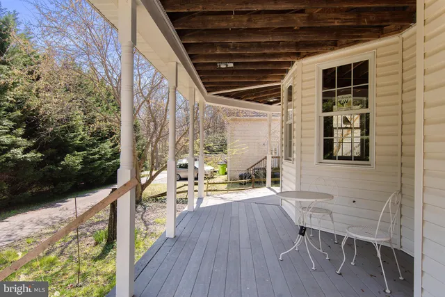 a view of porch with a bench and lawn chairs