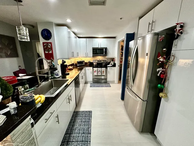 a kitchen with stainless steel appliances granite countertop a refrigerator and a sink