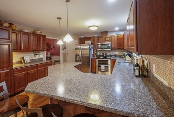 888 Florence Road Northampton, MA 01062 - Photo 15 of 37 a kitchen with stainless steel appliances granite countertop a sink a stove and a wooden cabinets