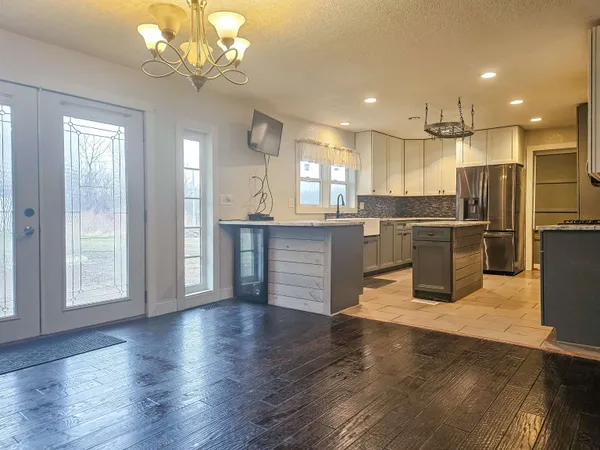 a kitchen with stainless steel appliances kitchen island granite countertop a refrigerator and a stove top oven